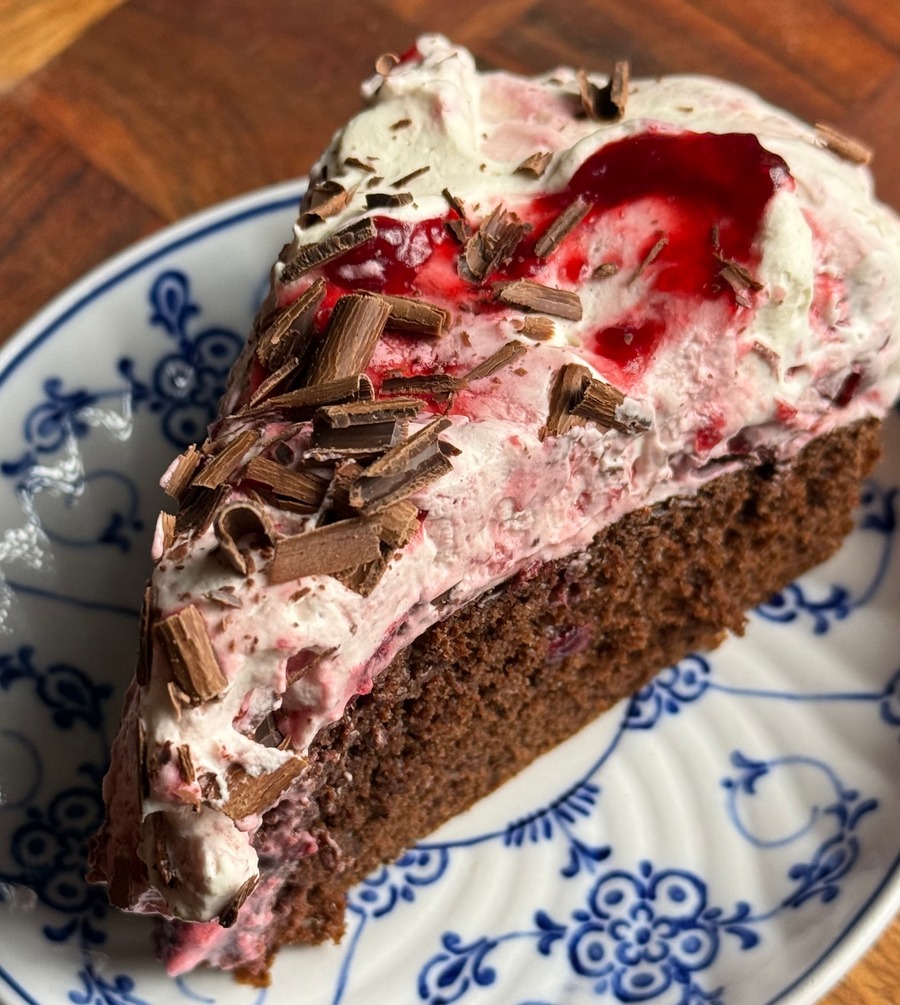 En bit black forest cake med grädde och körsbär